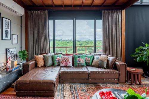 a leather couch in a living room with a large window at Principado dos Galgos, Chácara in Cascavel
