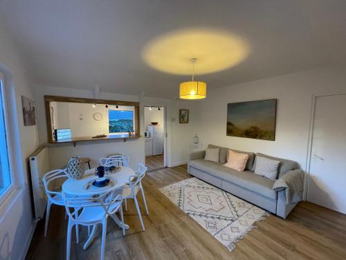 a living room with a couch and a table and chairs at Little Omaha in Vierville-sur-Mer