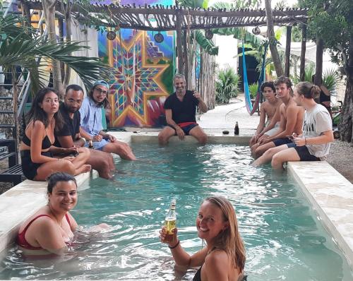 a group of people sitting in a swimming pool at Guaya Hostel in Mérida