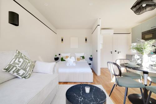 un salon avec un canapé blanc et une table dans l'établissement La Maison Bizot 51 T1 by ecoflats, à Paris