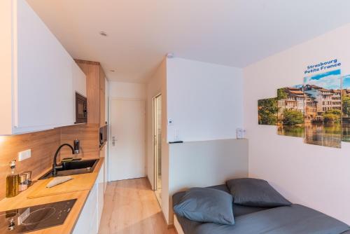 - une cuisine avec évier et un lit dans une chambre dans l'établissement Suite 1 - Strasbourg Gare - Petite France - Commerces à Proximité, à Strasbourg