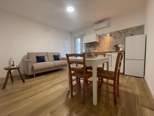a kitchen and living room with a table and a refrigerator at Villa Gargano in Mattinata