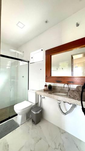 a bathroom with a toilet and a sink and a mirror at Chalé Vô Totõe - em Imbassaí in Imbassai