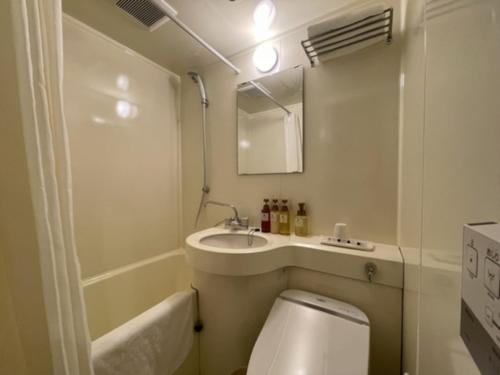 a bathroom with a toilet and a sink and a mirror at Kusatsu Daiichi Hotel - Vacation STAY 99256v in Kusatsu
