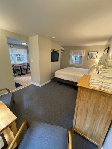 a hotel room with a bed and a dining room at Elmwood Motor Court in Old Orchard Beach