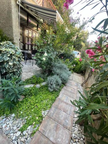 a garden with flowers and plants in front of a house at Guesthouse Klečak in Cavtat