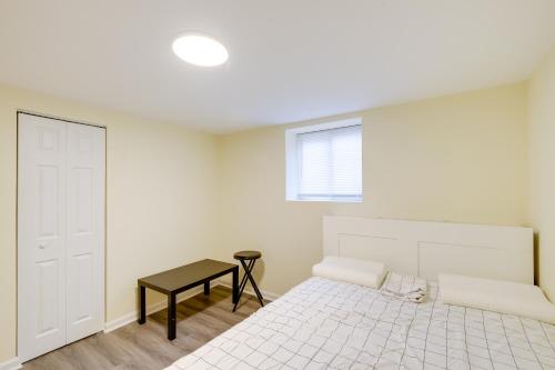 a white bedroom with a bed and a table at 1 Mi to Metro DC Area Apt with Fenced Yard! in Silver Spring
