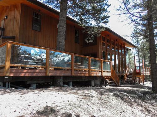 a large wooden house with a large deck at Canmore Alpine Hostel - Alpine Club of Canada in Canmore
