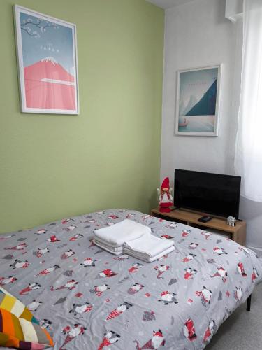 une chambre avec un lit avec une couette dessus dans l'établissement Centre Strasbourg, à Strasbourg