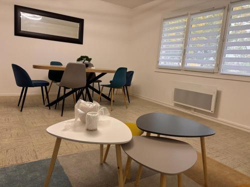 une chambre avec deux tables, des chaises et une table dans l'établissement Entre Loire and Chateaux - Appartement 2 Chambres, à Saint-Laurent-Nouan