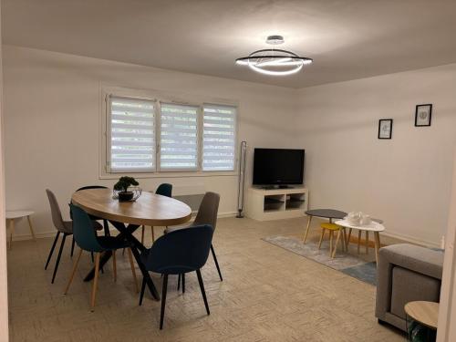 un salon avec une table, des chaises et une télévision dans l'établissement Entre Loire and Chateaux - Appartement 2 Chambres, à Saint-Laurent-Nouan