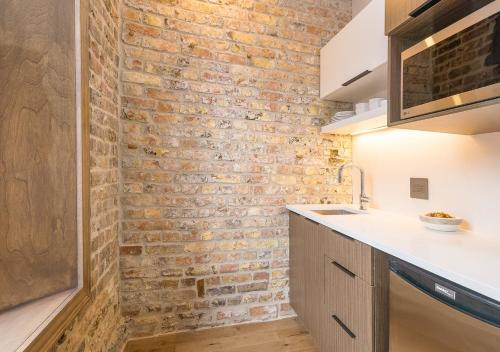 a brick wall in a kitchen with a sink at La Maison Kent - Par Aneyro in Quebec City