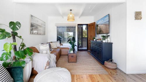 a living room with a couch and a table at Casa Blu in Culburra Beach