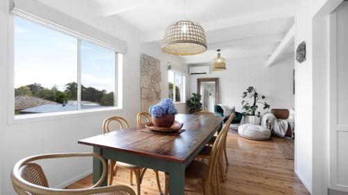 a dining room with a wooden table and chairs at Casa Blu in Culburra Beach