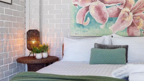 a bedroom with a bed and a painting on the wall at Casa Blu in Culburra Beach