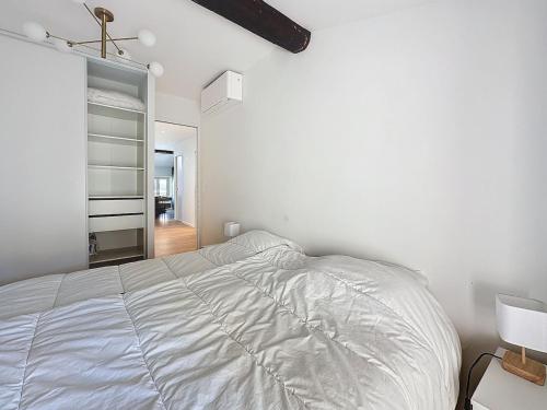 une chambre blanche avec un lit et un placard dans l'établissement 54m2 hypercenter, face Palais des Festivals, à Cannes