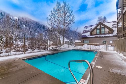 a swimming pool in front of a house in the snow at Viking Lodge B218 in Telluride