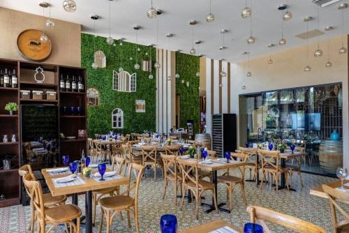 a restaurant with wooden tables and chairs and a green wall at Disney Escape Modern 3BR Townhouse 2 Miles to the Parks 4 Baths in Orlando