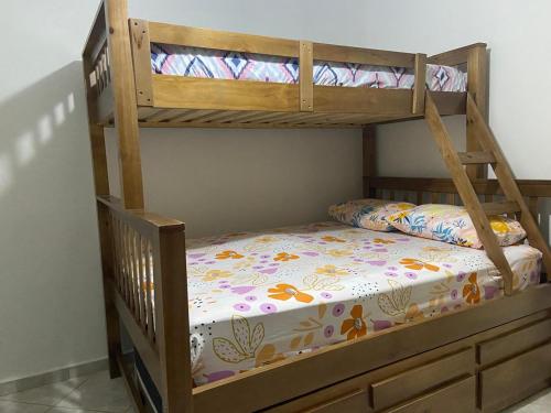 a bunk bed with a wooden bunk bed frame at Edifício Bandeirantes in Praia Grande