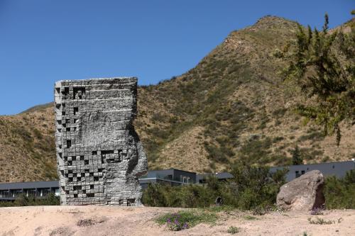 a tall stone tower in front of a mountain at Puesto del Indio in Mendoza