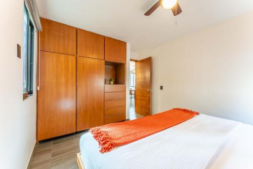 a bedroom with a bed and a wooden cabinet at Ocean Breeze Condo 1 block F beach in Cabo San Lucas