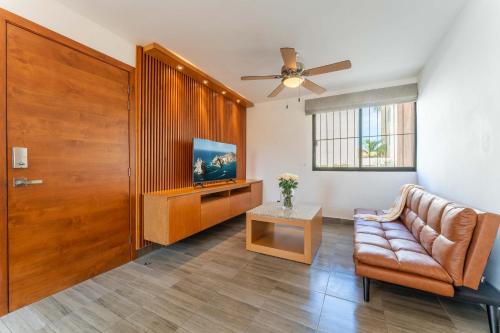 a living room with a couch and a television at Ocean Breeze Condo 1 block F beach in Cabo San Lucas