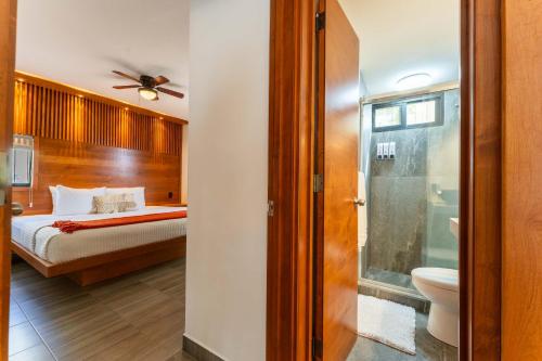 a bedroom with a bed and a bathroom with a toilet at Ocean Breeze Condo 1 block F beach in Cabo San Lucas