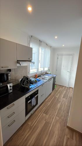 une cuisine avec des appareils blancs et un parquet dans l'établissement Appartement Nice promenade des anglais aéroport, à Nice