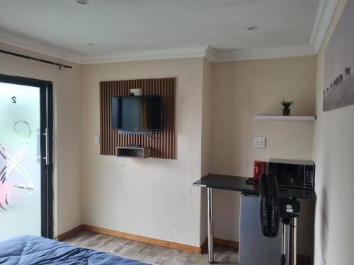 a room with a counter and a tv on the wall at Eazistay Motel - Letlhabile in Brits