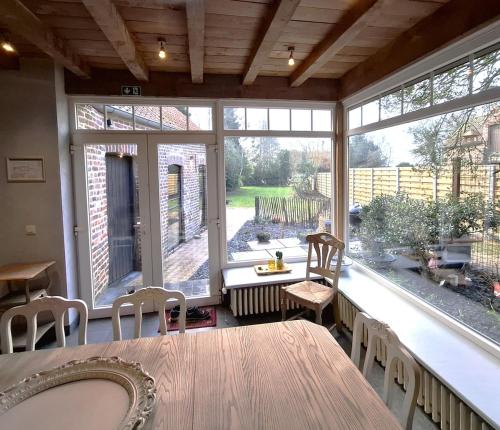 a large screened in porch with a table and chairs at l'Amourette de Jeanne in Houthulst