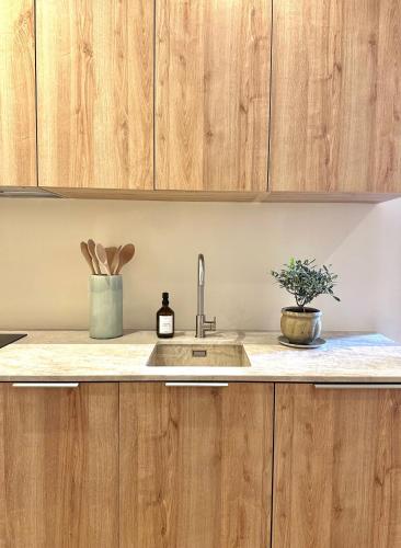 une cuisine avec des armoires en bois et un évier dans l'établissement l'Alceste, à La Ciotat