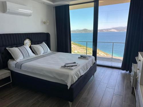 a bedroom with a bed with a view of the ocean at Villa Paradise in Milas