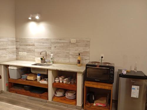 a kitchen with a counter with a sink and a microwave at Quincho El Solar in Corrientes