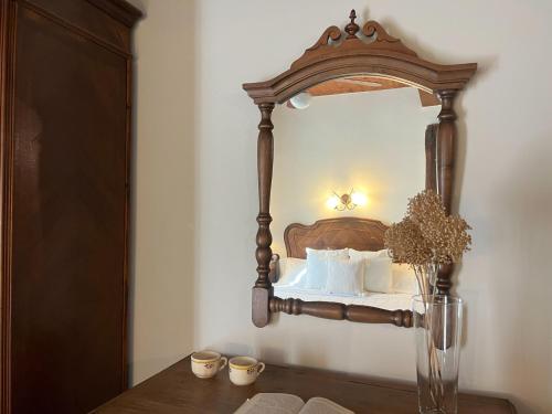 a bedroom with a wooden bed with a mirror at Casa Rural La Fuente del Jerte in Navaconcejo