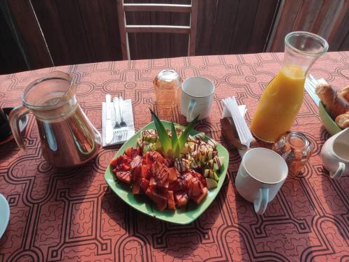 un piatto di cibo su un tavolo con succo d'arancia di Valencia Lake Lodge a Puerto Maldonado