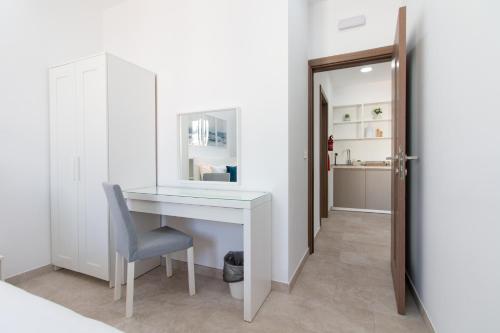 a white desk with a chair in a room at Sandstone Apartment 17 in Marsaskala