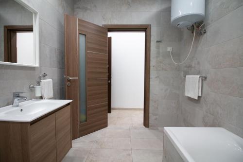 a bathroom with a sink and a toilet and a mirror at Sandstone Apartment 17 in Marsaskala