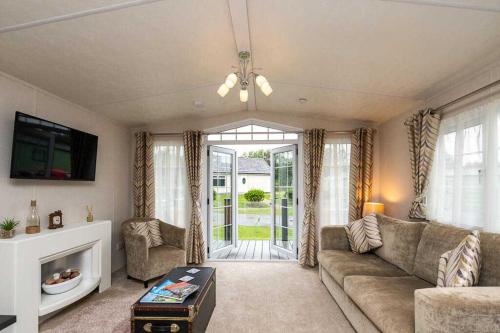 a living room with a couch and a tv at Stylish and cozy holiday home in Carnforth
