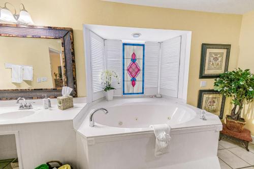 a bathroom with a tub and two sinks and a mirror at Windemere Inn by the Sea in Melbourne
