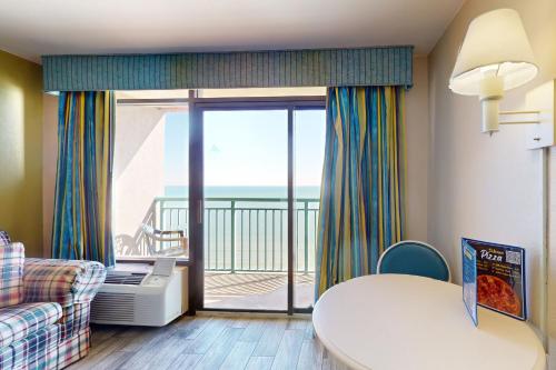 a living room with a couch and a room with a balcony at Sandcastle South 1506 in Myrtle Beach
