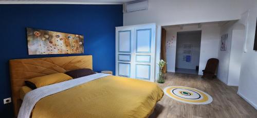 - une chambre avec un lit jaune et un mur bleu dans l'établissement Le Mas des Lucioles à Vinezac, à Vinezac