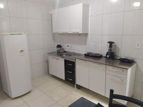 Una pequeña cocina con nevera y fregadero. en Apartment 203 Charming, en Vitória da Conquista