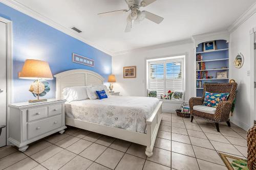 a bedroom with a bed and a chair and a fan at Windemere Inn by the Sea in Melbourne