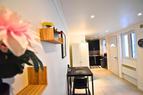 un salon avec une table et un réfrigérateur dans l'établissement Urban Chic Paris, aux Lilas