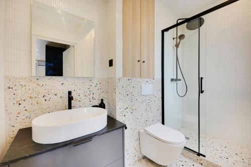une salle de bain avec un lavabo, des toilettes et une douche dans l'établissement La Maison Bizot 41 T1 by ecoflats, à Paris