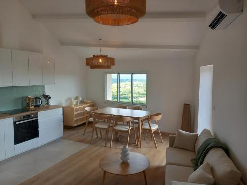 une cuisine et un salon avec une table et un canapé dans l'établissement Appartement panoramique, clim, terrasse, 6 personnes, à Lacoste