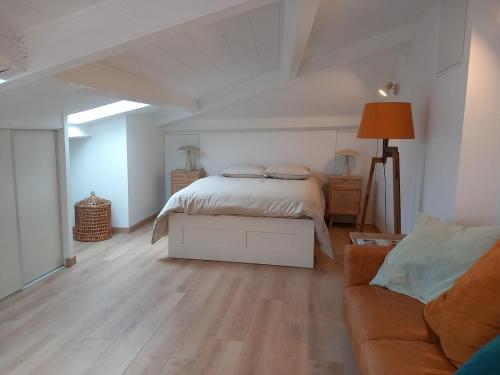 - une chambre blanche avec un lit et un canapé dans l'établissement Appartement panoramique, clim, terrasse, 6 personnes, à Lacoste