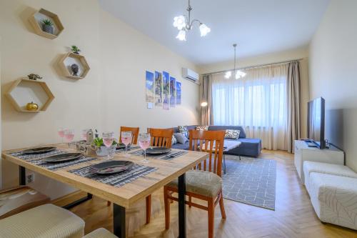 a dining room and living room with a table and chairs at Grand Luxury Condo by NDK and National Stadium with Free Parking in Sofia
