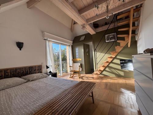 - une chambre avec un lit et un escalier dans l'établissement Les nuitées de larlesienne, à Saint-Michel-Loubéjou