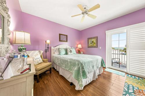 a bedroom with purple walls and a bed and a window at Windemere Inn by the Sea in Melbourne